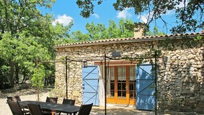 A stone building with a tiled roof, a wooden door, and a covered patio area with a table and chairs. - Wonderful private villa for 6 people with private pool, TV, patio and pets allowed (Moissac-bellevue)
