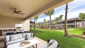 Un espacio exterior moderno con sala, mesa de comedor y ventilador de techo.