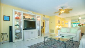 A living room with a television, sofa, coffee table, and decorative items.