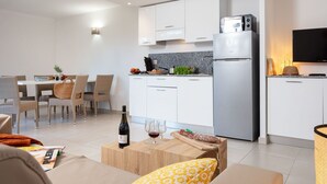 A modern apartment with a dining area, kitchen, and living space. - Nice apartment for 6 people with A/C, pool, internet, TV, balcony and pets allowed (Santa-lucia-di-moriani)