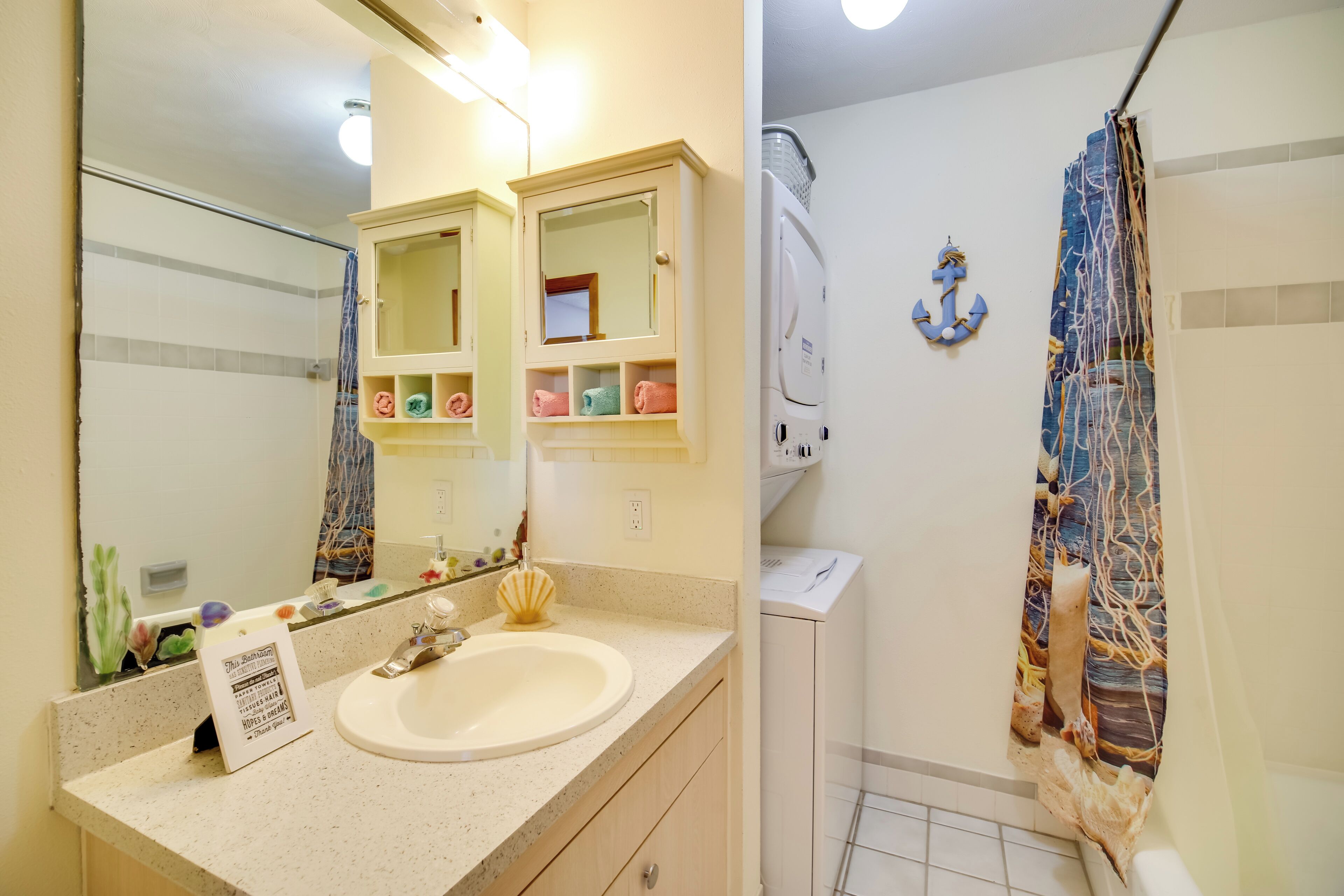 A bathroom with a sink, mirror, towel rack, and shower curtain.