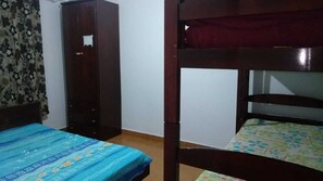 A room with a bunk bed, a wardrobe, and a bed with a patterned bedspread. - Apartment in front of the beach Vl. Caiçara (Vila Caiçara)