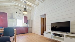 A modern kitchen with white cabinetry, a dining area with a table and chairs, and a living room with a flat-screen TV and entertainment unit. - Beautiful private villa for 4 people with WIFI, A/C, TV and terrace (Zadar)