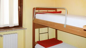 A bunk bed with a window and a radiator.