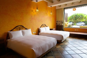 A hotel room with two beds, a large window with a view of the street, and a tiled floor. - Sand Hostel (Hengchun)