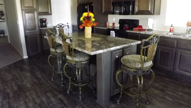 A kitchen with dark wood cabinets, a granite countertop, and a central island with bar stools. -  50% to Book the Gecko Home - Super Clean, Really Nice 3BR - Sleeps 6- By TNT. (Page)