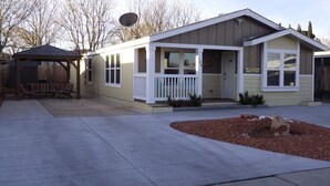 A single-story house with a front porch, a covered patio, and a small garden area. -  50% to Book the Gecko Home - Super Clean, Really Nice 3BR - Sleeps 6- By TNT. (Page)