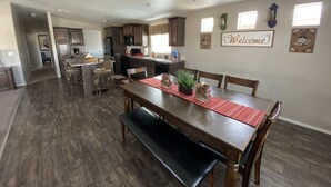 A spacious kitchen with dark wood cabinets, a central island, and a dining area with a wooden table and chairs. -  50% to Book the Gecko Home - Super Clean, Really Nice 3BR - Sleeps 6- By TNT. (Page)