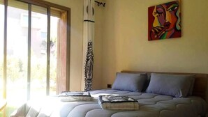 A bedroom with a large bed, a window with curtains, and a painting on the wall. - Apartment Marrakech Prestigia Golf City 4601 (Marrakech)