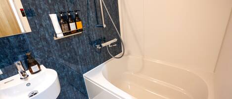 A modern bathroom with a white bathtub, a sink, and a shower.