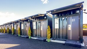 A row of modern, numbered hotel rooms with individual entrances and small potted plants. - Hotel R9 The Yard Yaita (Yaita)