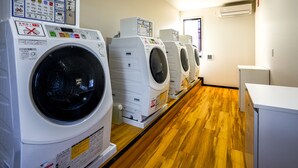 A row of white front-loading washing machines in a laundry room with wooden flooring and a white wall. - Hotel R9 The Yard Yaita (Yaita)