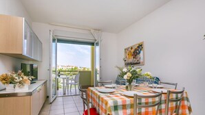 Ein Essbereich mit kariertem Tischläufer, roten Stühlen und einem Bild an der Wand.