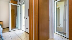 Un corridoio con porte scorrevoli in vetro che danno accesso alle camere da letto.