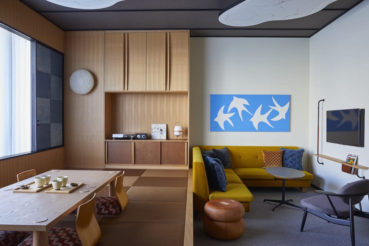 Un salon moderne avec une table à manger en bois, un canapé jaune et des tatamis.