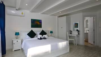 Un dormitorio con cama, mesitas de noche, escritorio y silla.