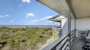 Un balcon avec vue sur la plage et l’océan.
