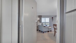 Une chambre d’hôtel avec un lit, une chaise, une table et une fenêtre.