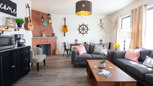 Ein gemütliches Wohnzimmer mit Kamin, einer Gitarre und einer Schiffslenkredekoration.