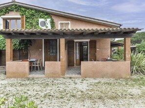 Ein Haus mit überdachter Terrasse, einer Glastür und einem Fenster mit Klimaanlage.