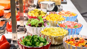 Buffet variat amb plats diversos, incloent amanides, fruites i pasta.