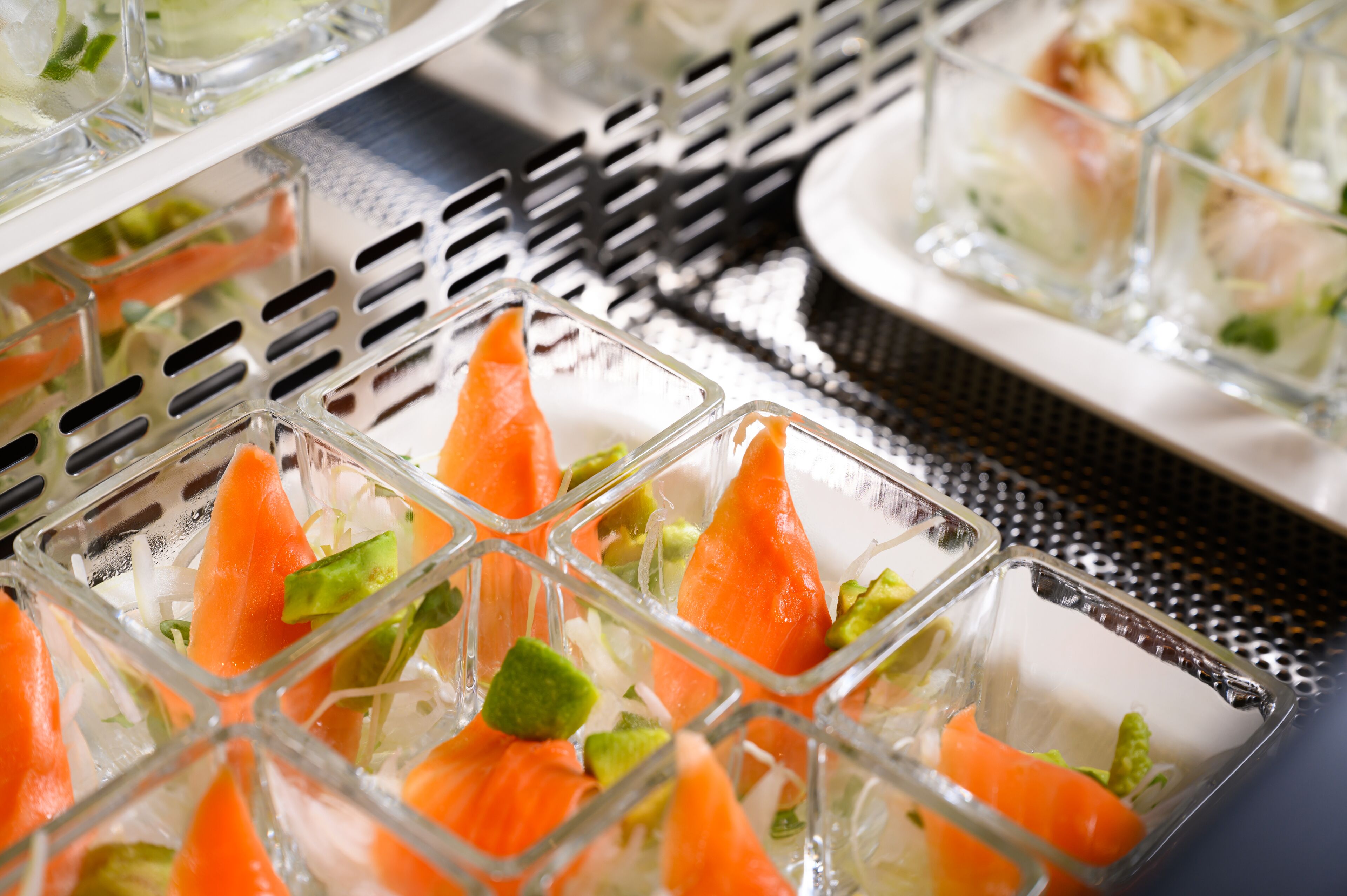 A buffet with clear glass containers holding food items.