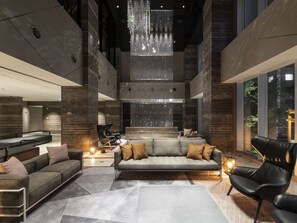 A spacious, modern lobby with a central seating area, a high ceiling with a decorative light fixture, and a view of the outdoors through large windows. - Hotel Forza Sapporo Station (Sapporo)