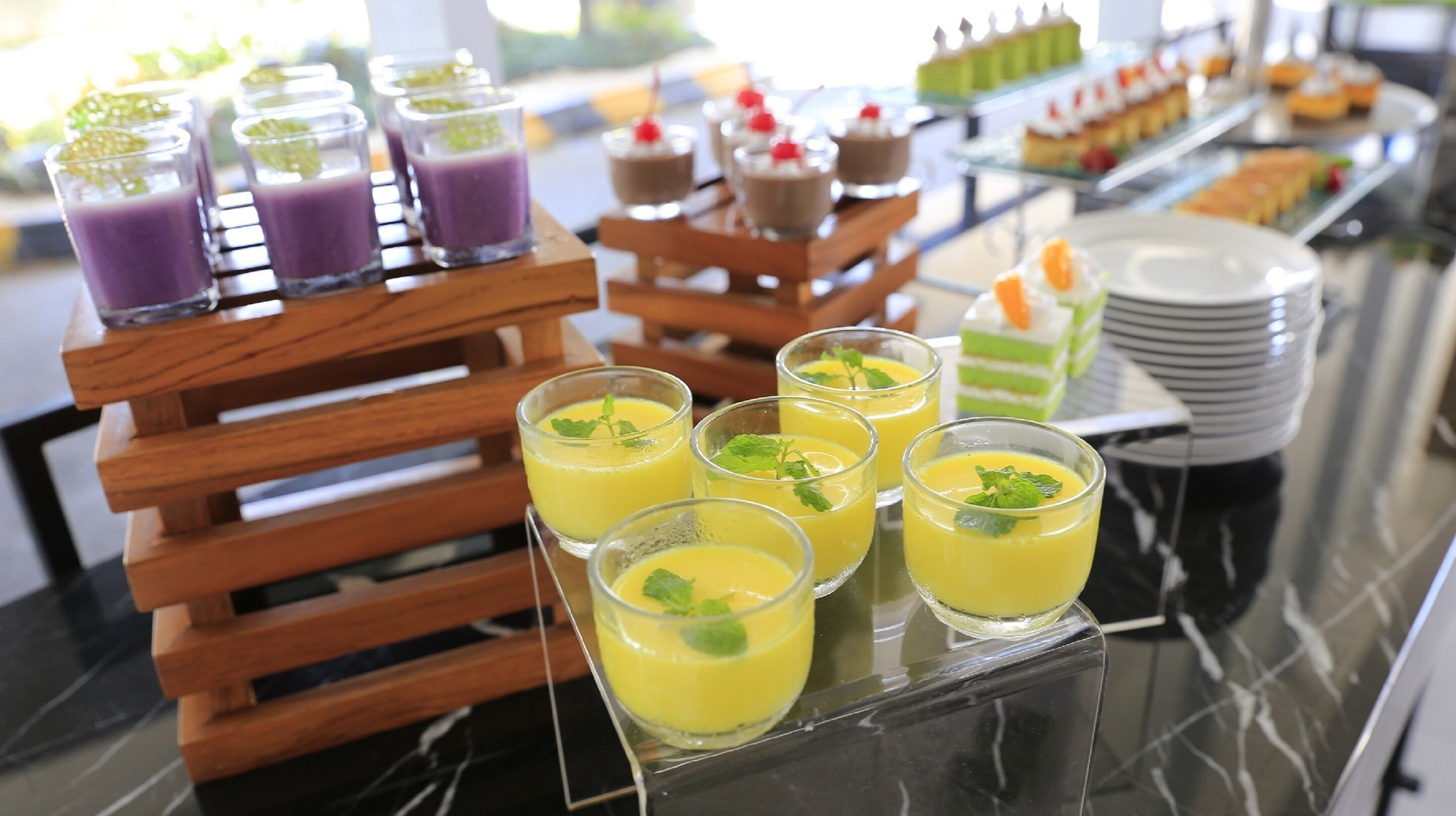 A buffet with various food and drink options, including a selection of desserts and beverages.