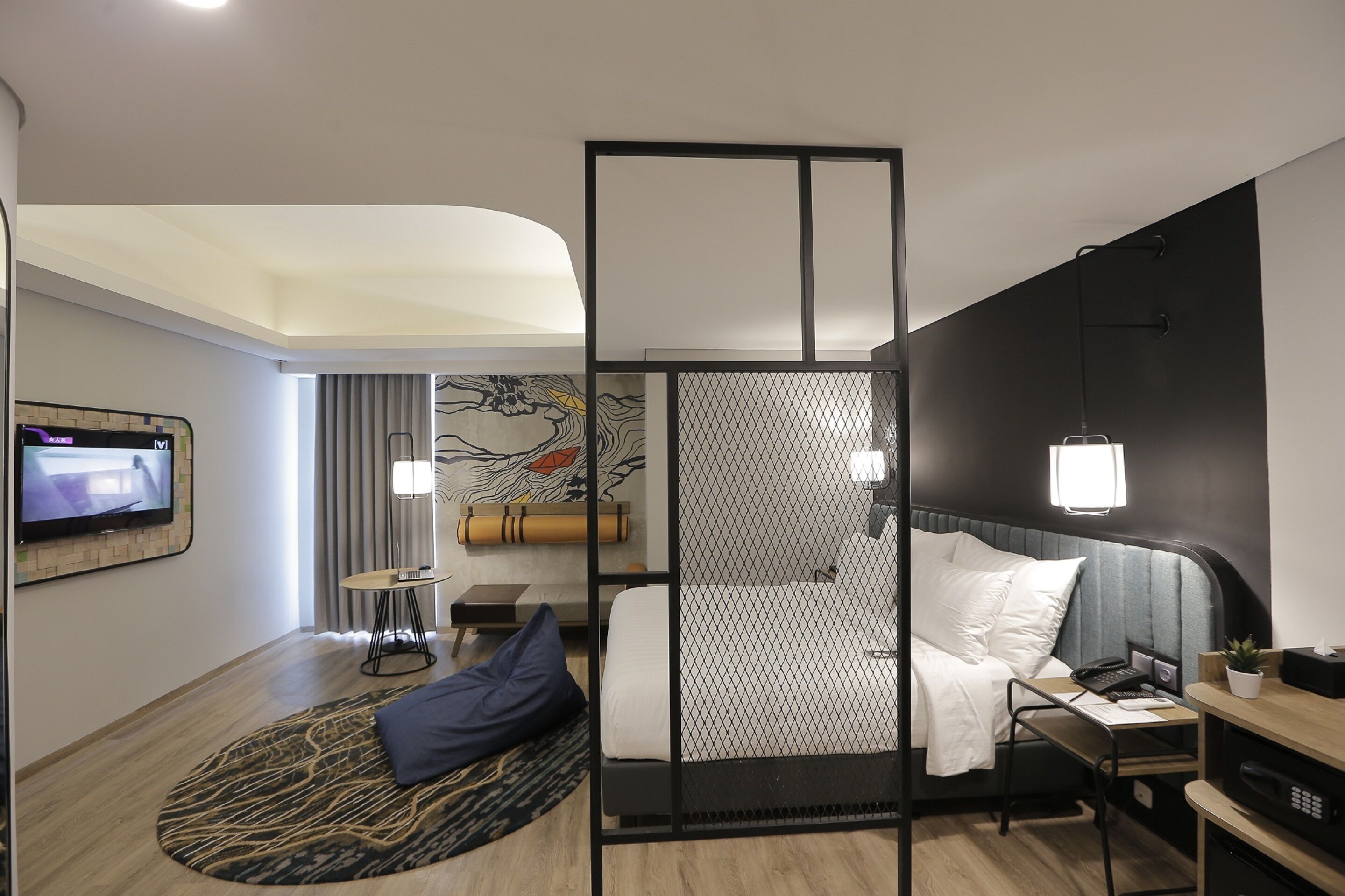 Una habitación de hotel moderna con cama, escritorio y televisión.