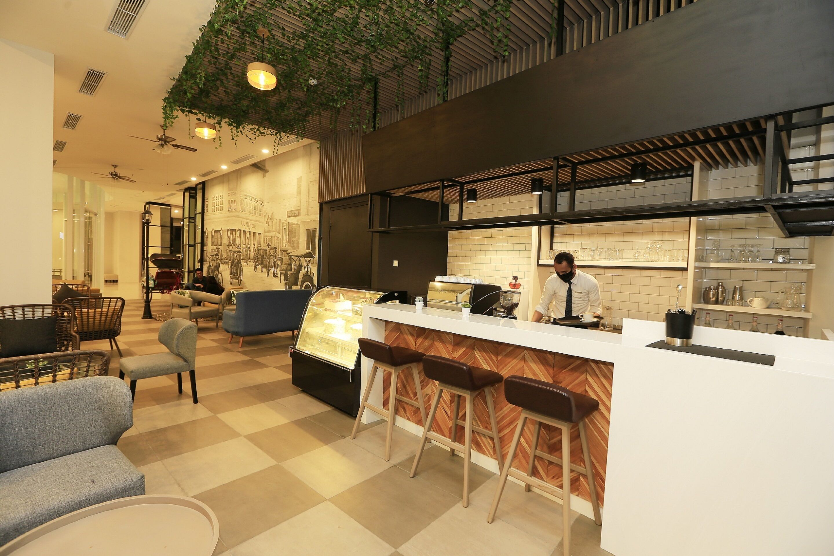 A modern cafe with a bar area, seating, and a display case.