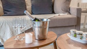 Une table en bois avec une bouteille de champagne, des verres et une bougie.