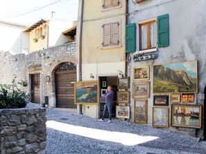 A street with a building displaying various framed artworks.