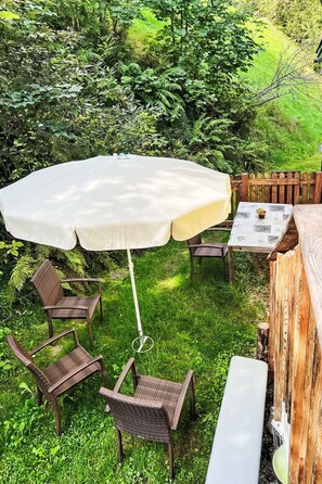 An outdoor patio with a table, chairs, and a large umbrella.