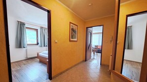 A hallway with a bed, a radiator, and a window with curtains. - Lovely apartment for 3 guests with WIFI, TV and balcony (Thurmbach)