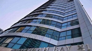 Un edificio moderno con fachada curva y grandes ventanales. Se puede leer 