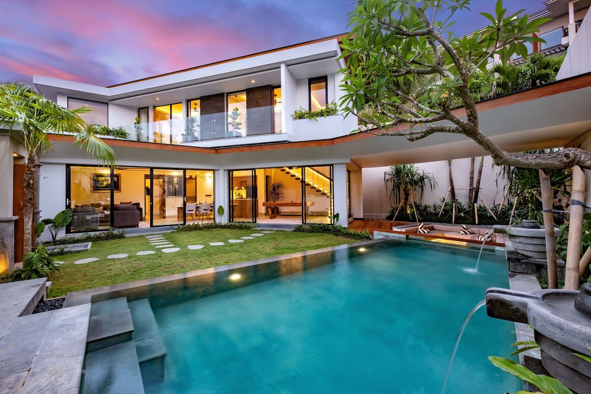 Une maison moderne à deux étages, dotée d’une piscine, d’un espace extérieur aménagé et d’un jardin bien entretenu.
