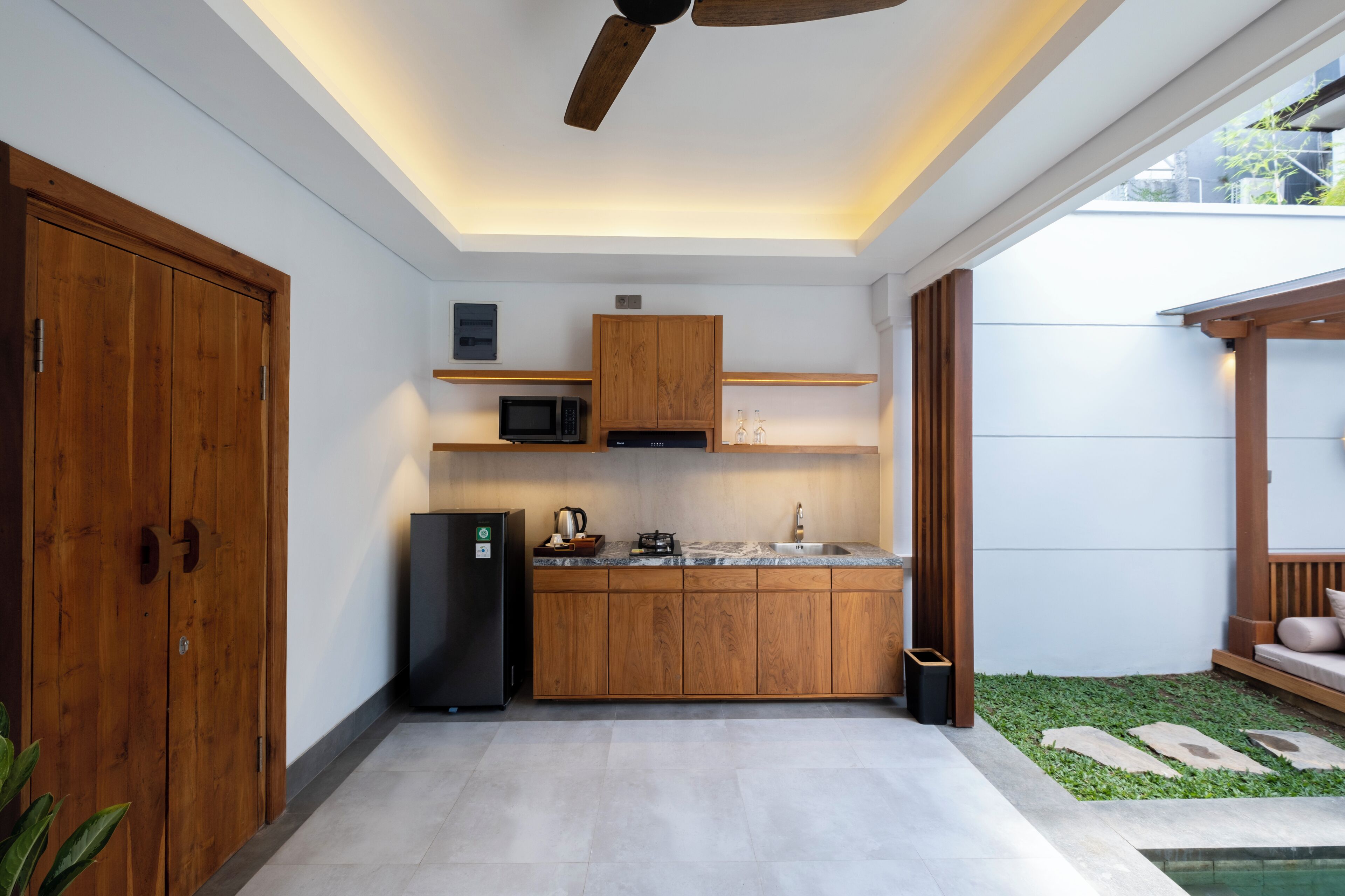 A modern kitchen with wooden cabinets, a black refrigerator, and a microwave.