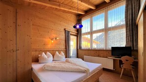 A wooden cabin bedroom with a bed, a desk with a television, and a chair. - Nice apartment for 2 guests with WIFI, TV and balcony (Solden)