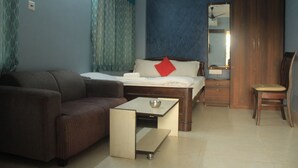 Une chambre à coucher comprenant un lit, un canapé, une petite table, une chaise et une armoire.