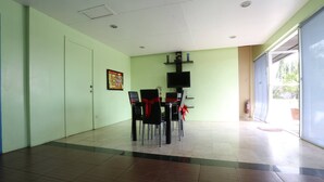 Un salón de conferencias con una mesa, sillas, un televisor y una puerta.