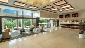A spacious lobby with a high ceiling, large windows, and a seating area with modern furniture. - The Fern Kolhapur, Series by Marriott (Kolhapur)