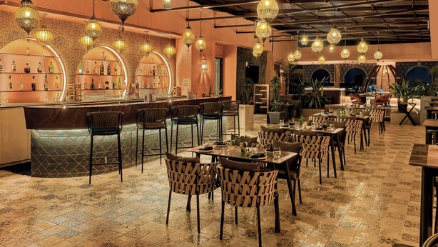 A restaurant with a bar area, multiple seating arrangements, and hanging decorative lights. - The Fern Kolhapur, Series by Marriott (Kolhapur)