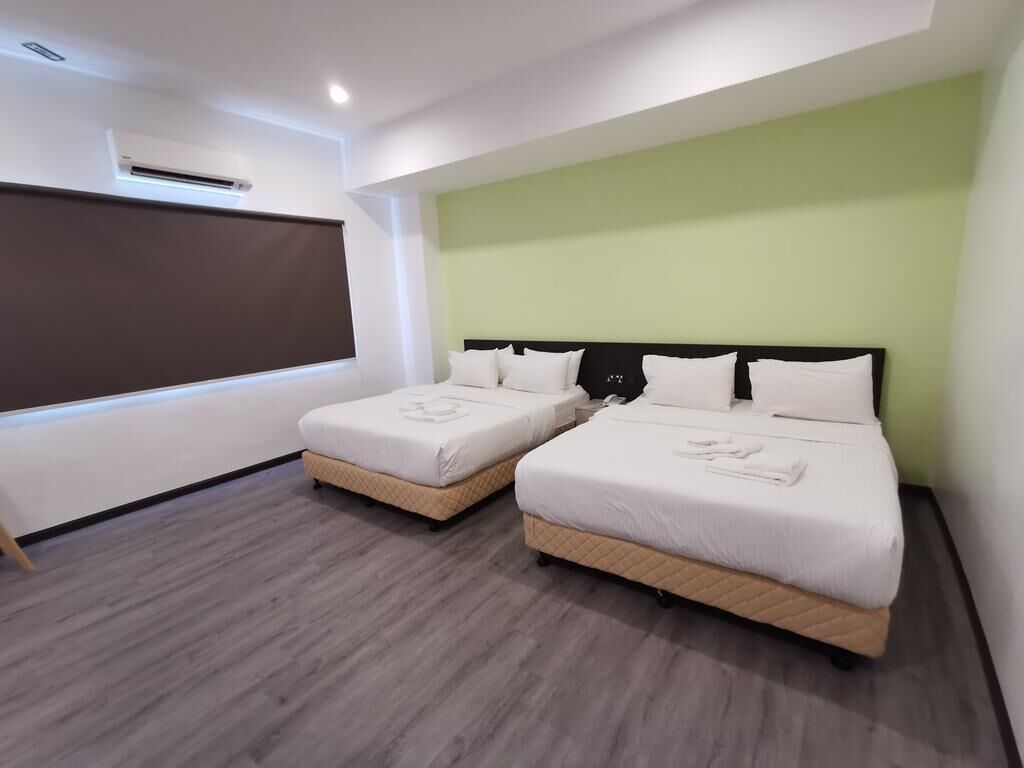 Een moderne hotelkamer met twee bedden, een groot raam en een flatscreen televisie.