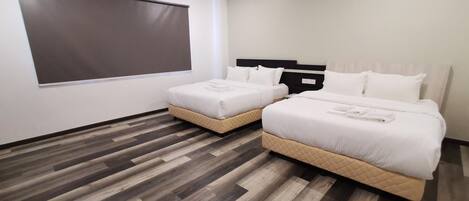 A hotel room with two beds, a large window, and a modern design.