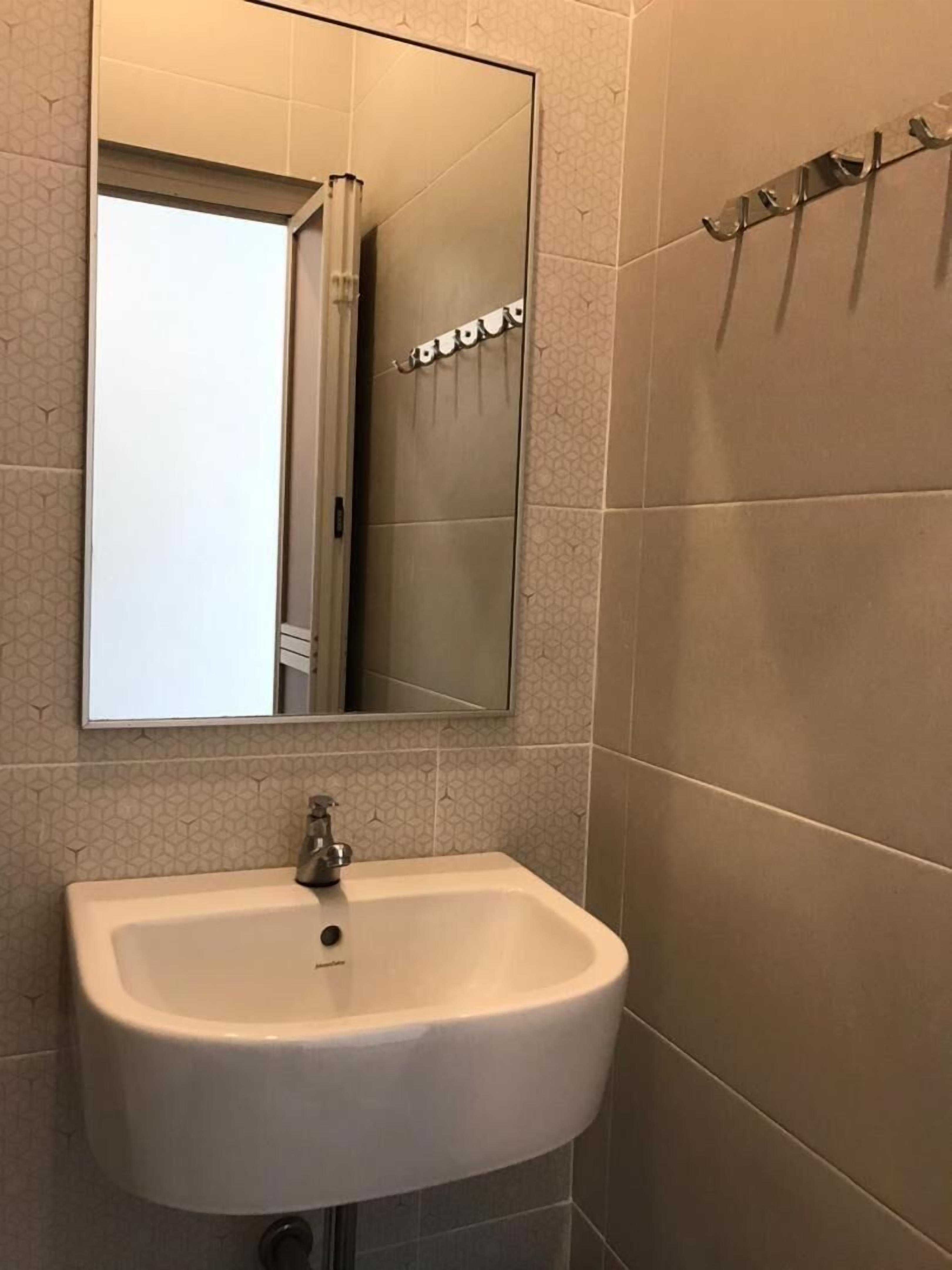 A bathroom with a white sink, a mirror, and a towel rack.