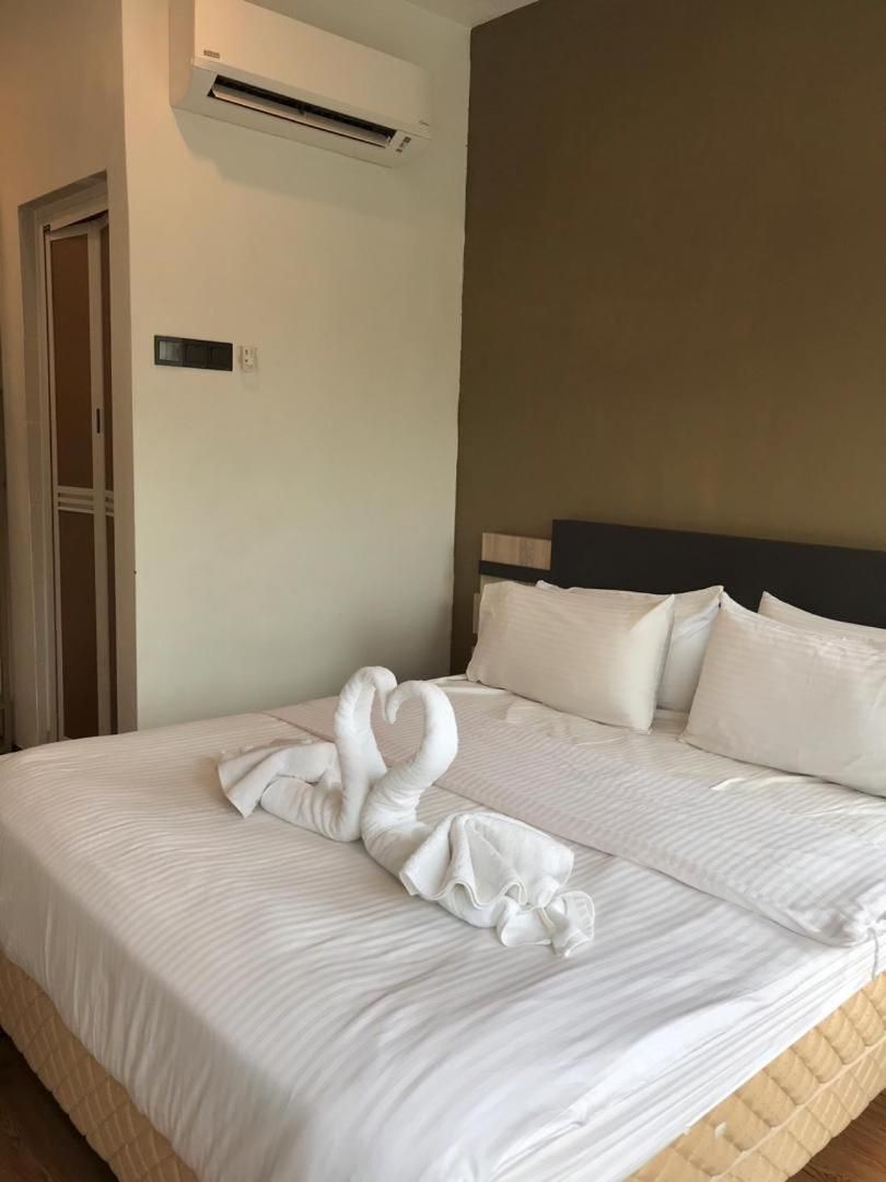 Ein Hotelzimmer mit Bett, Kissen, Klimaanlage und einer Tür.