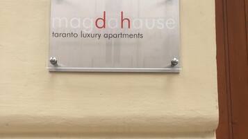Un letrero con la inscripción 'madahouse taranto luxury apartments' colocado en una pared.