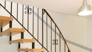 Eine Holztreppe mit schwarzen Metallgeländern und einer weißen Wand.