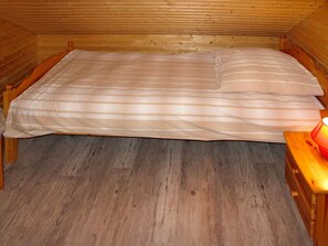 Cozy retreat with a single bed, bedside table, and lamp.