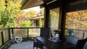 Eine Terrasse mit Tisch und Stühlen, einer herzförmigen Dekoration und einem Blumenvasen.